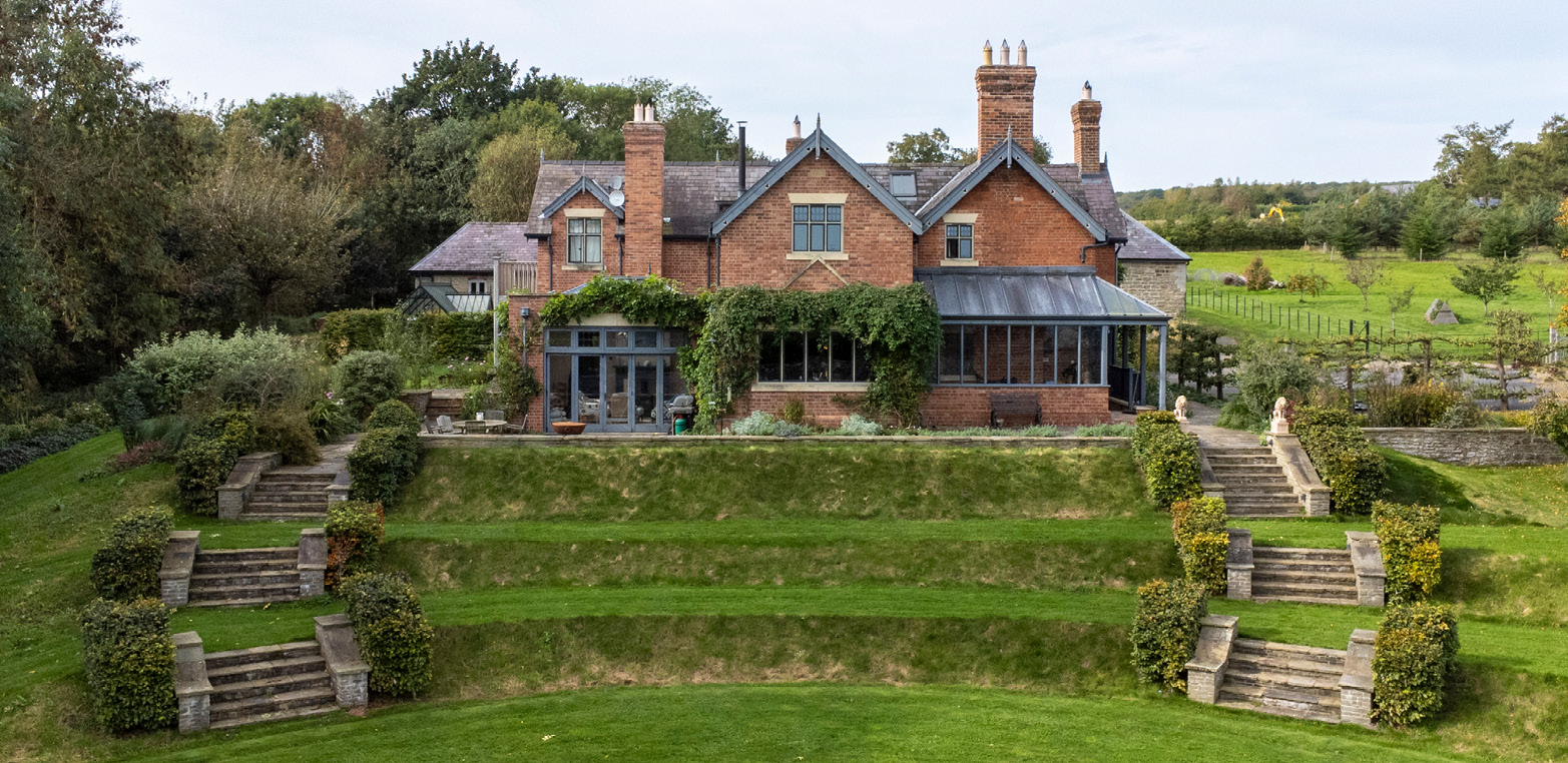 drone shot of victorian farmhouse